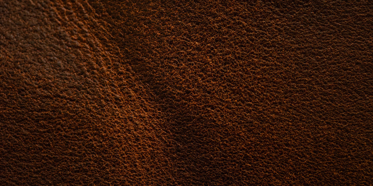close up swatch of rough shot leather showing texture and color variation