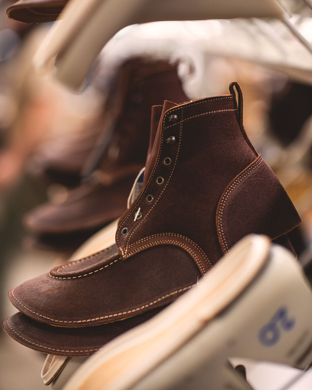 brown rough out boot uppers with lasts waiting to be lasted
