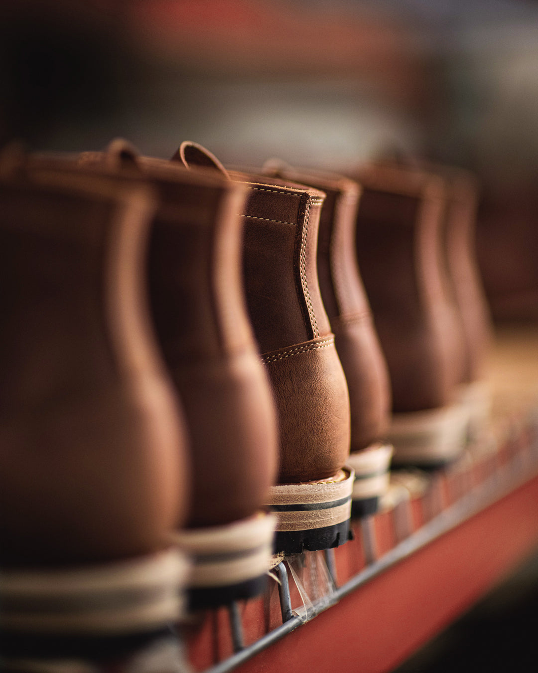 brown leather moc toe boots from behind waiting on finishing rack