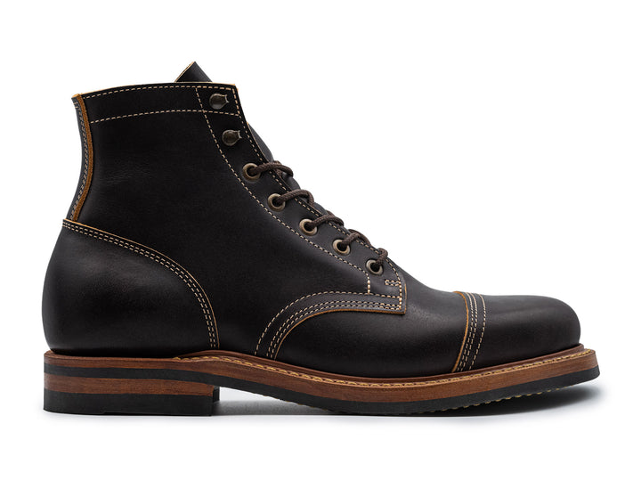 side view of black leather boot on white background