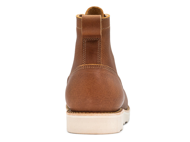 rear view of light brown leather moc toe boot on white background