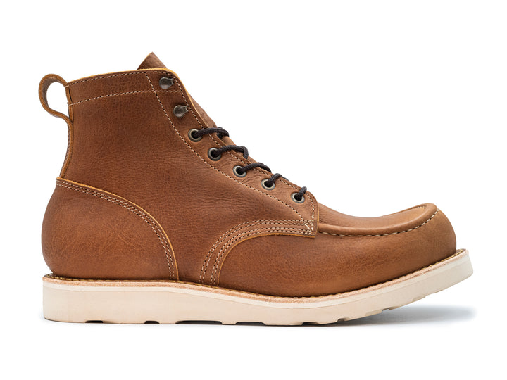 side view of light brown leather moc toe boot on white background
