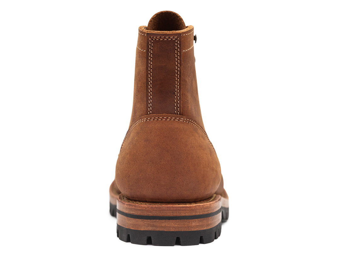 back view of brown leather moc toe boot on white background