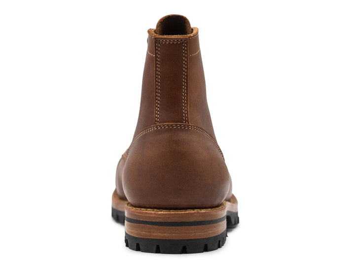 Brown leather boot on a white background back view