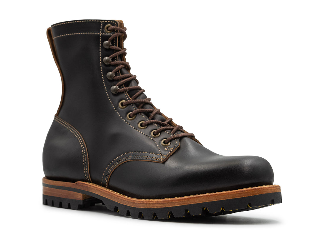 three-quarter view of tall black leather boot on white background
