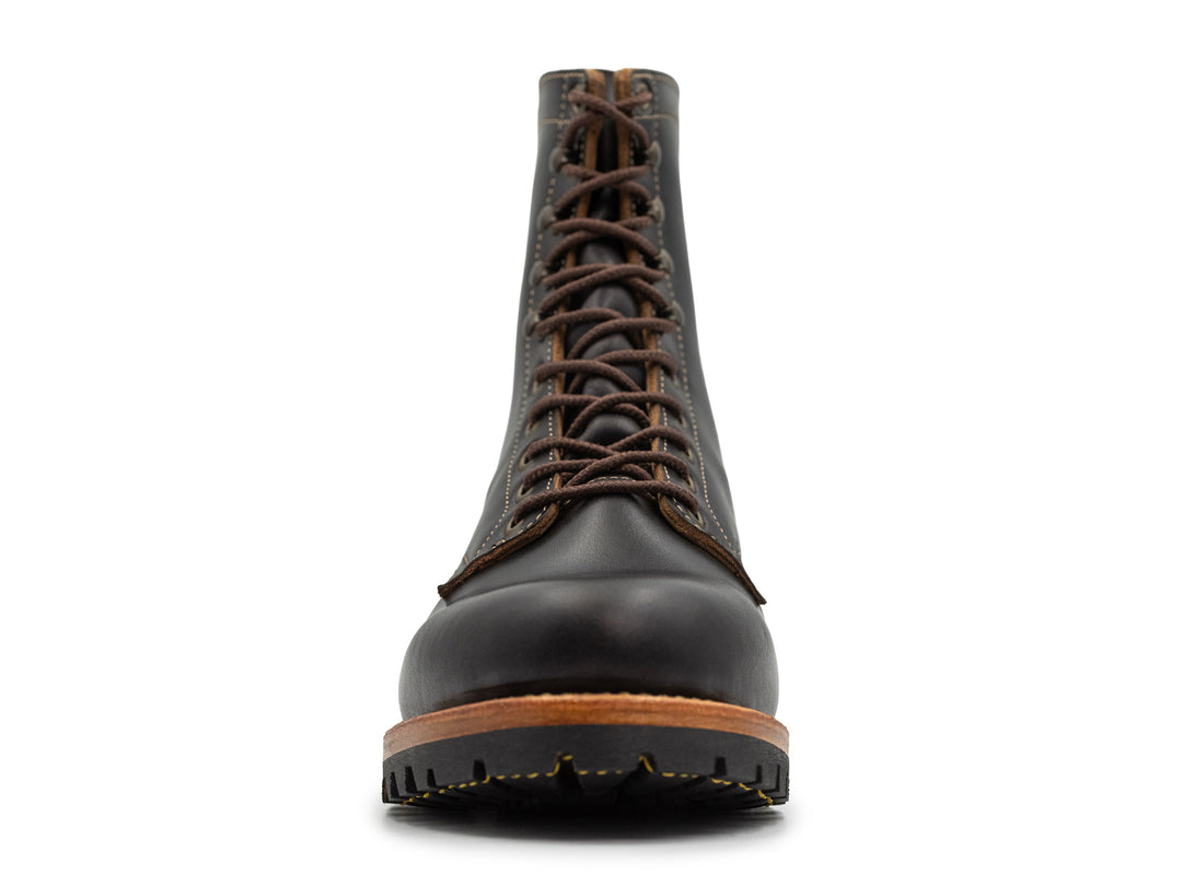 front view of tall black leather boot on white background