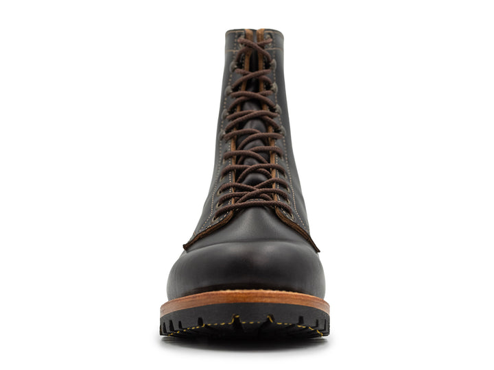front view of tall black leather boot on white background