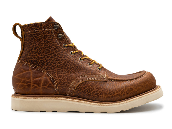 side view of cognac shrunken bison moc toe boot on white background