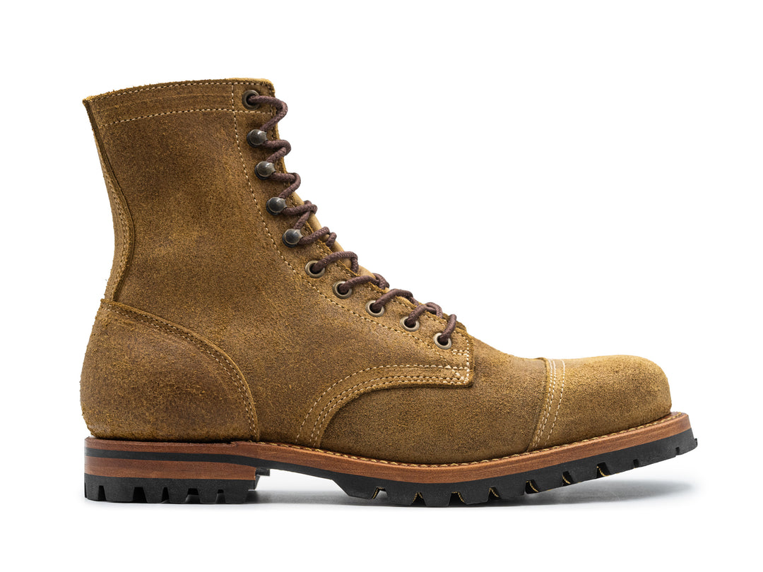 side view of coyote oiled rough out leather boot on white background
