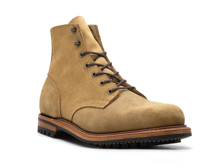 three-quarter view of tan leather boot on white background