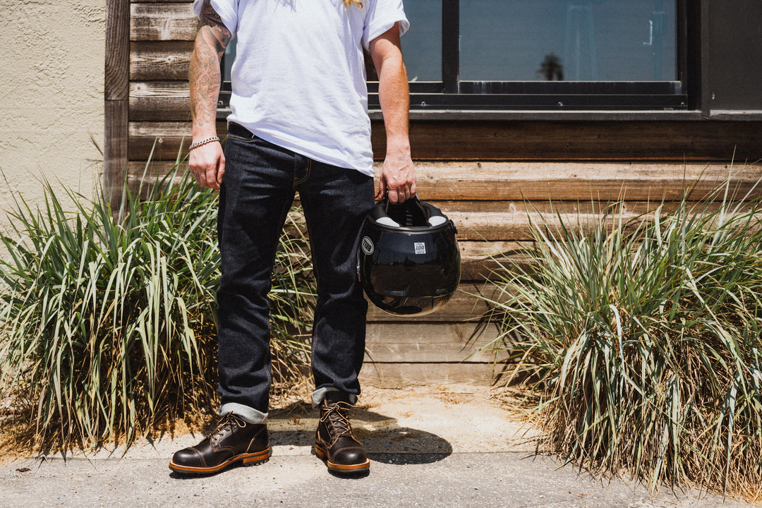 man in selvage denim with Truman black waxed flesh boots and motorcycle helmet