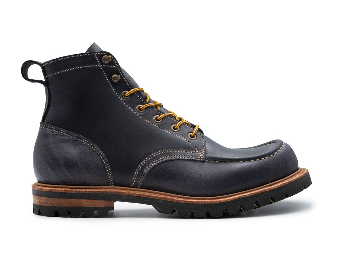 side view of steel blue leather boot on white background