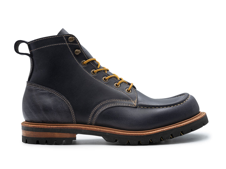 side view of steel blue leather boot on white background