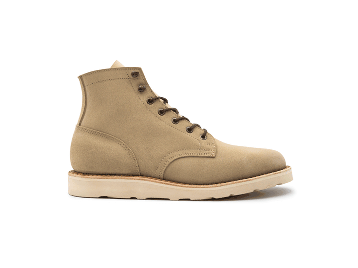 Tan boot with a white sole on a white background rotating 360° view