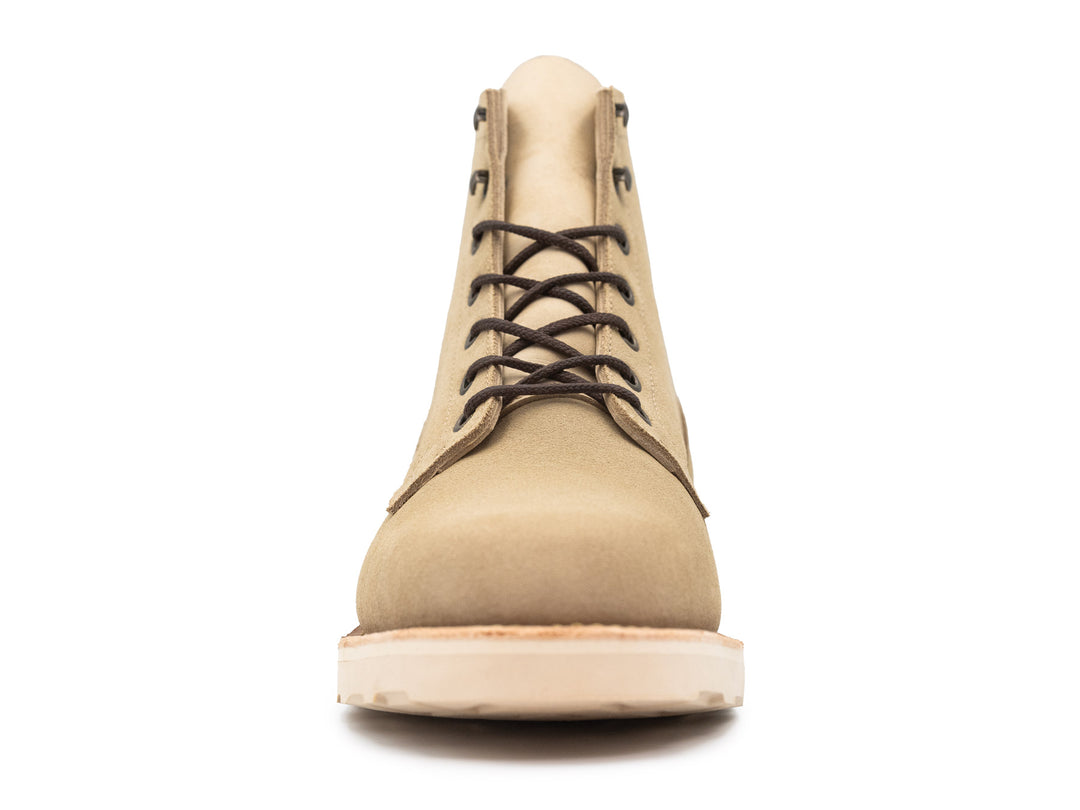 Tan boot with a white sole on a white background front view