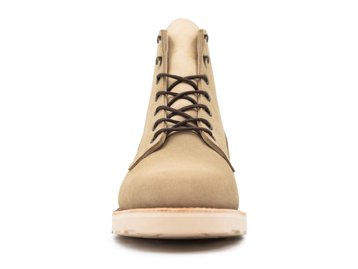 Tan boot with a white sole on a white background front view