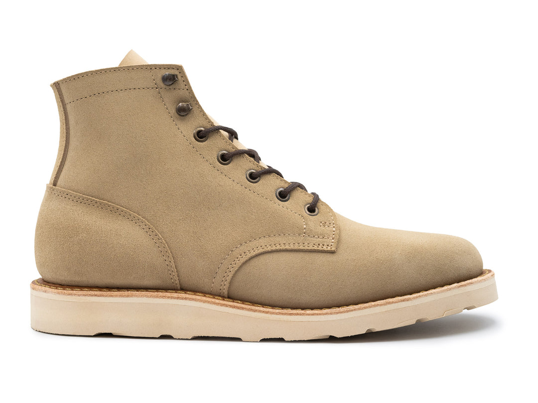 Tan boot with a white sole on a white background side view