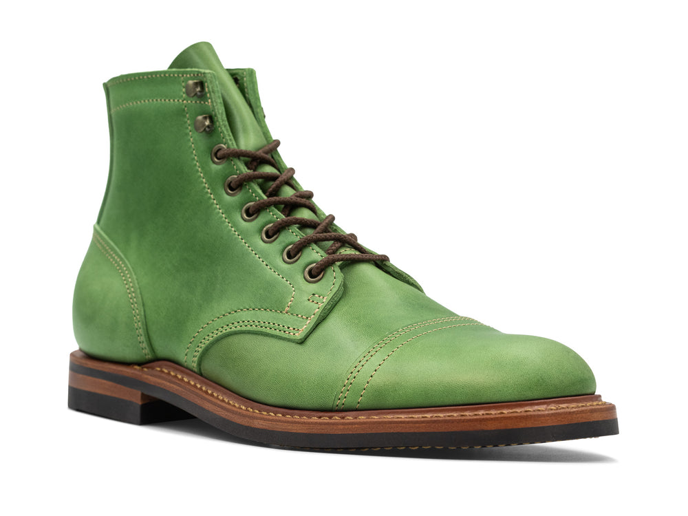 three quarter view of green leather boot on white background