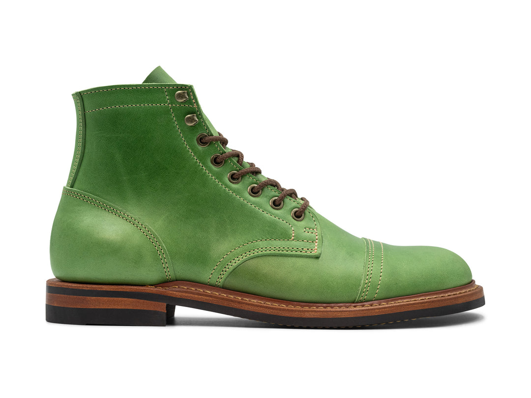 side view of green leather boot on white background