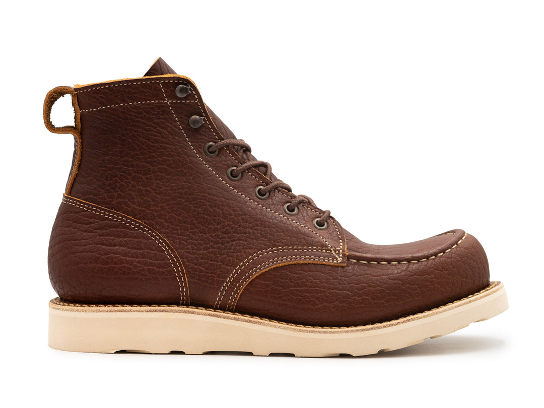 side view of brown textured leather moc toe boot on white background