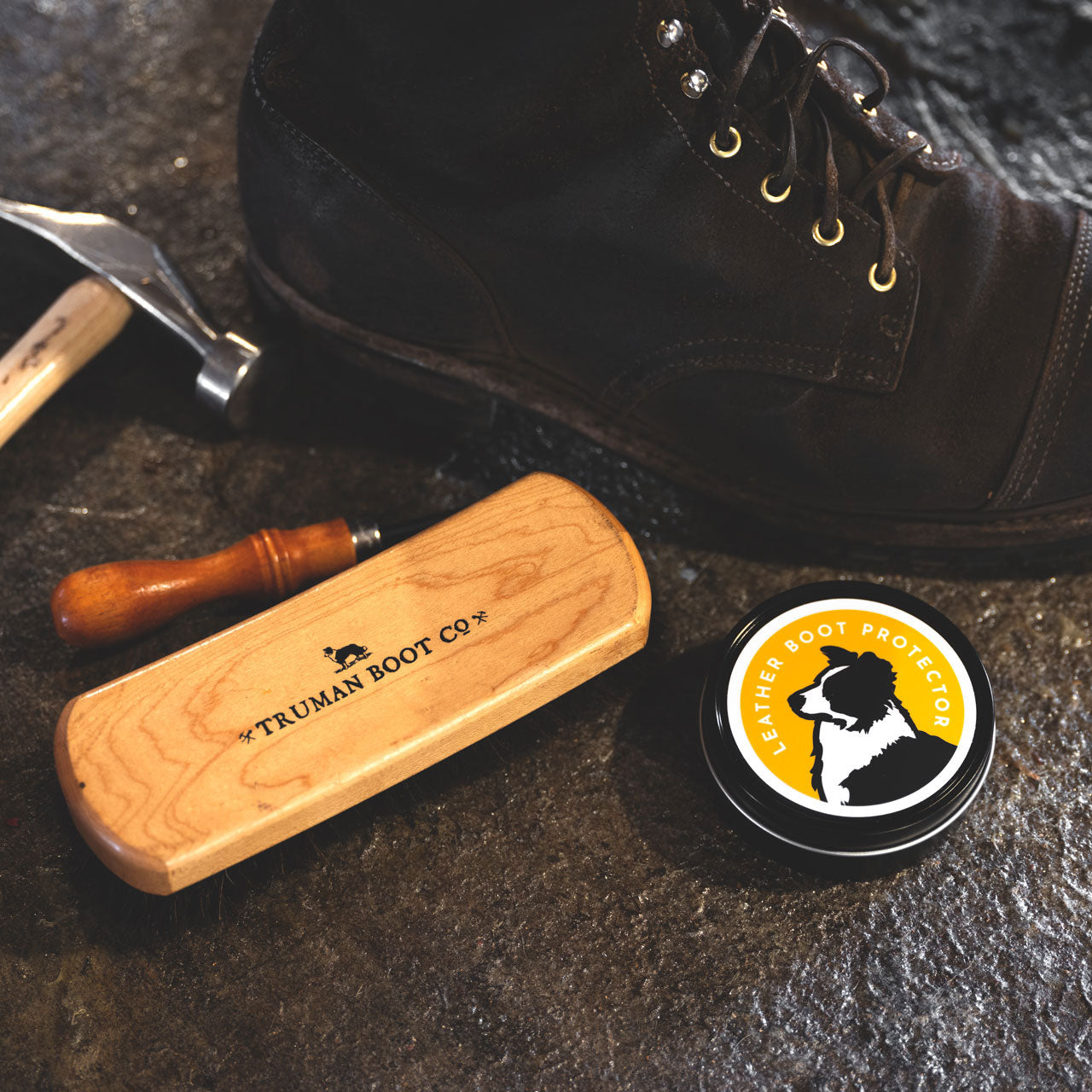 Truman leather boot protector next to worn boot and horsehair brush