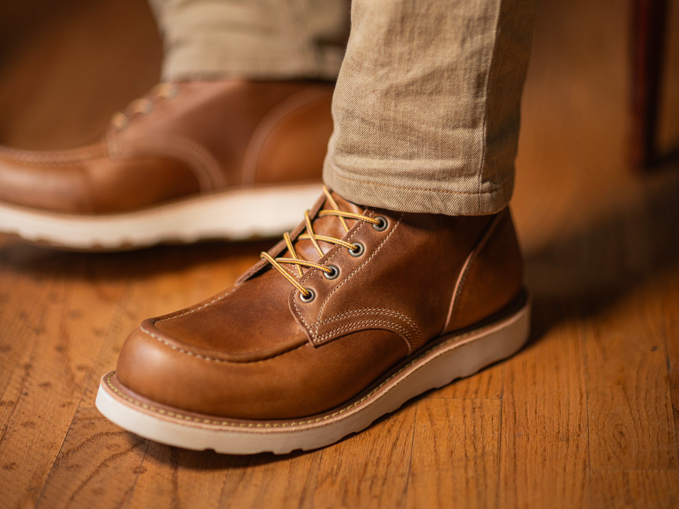 close up shot of man wearing khaki pants and caramel tan leather boots on wedge sole