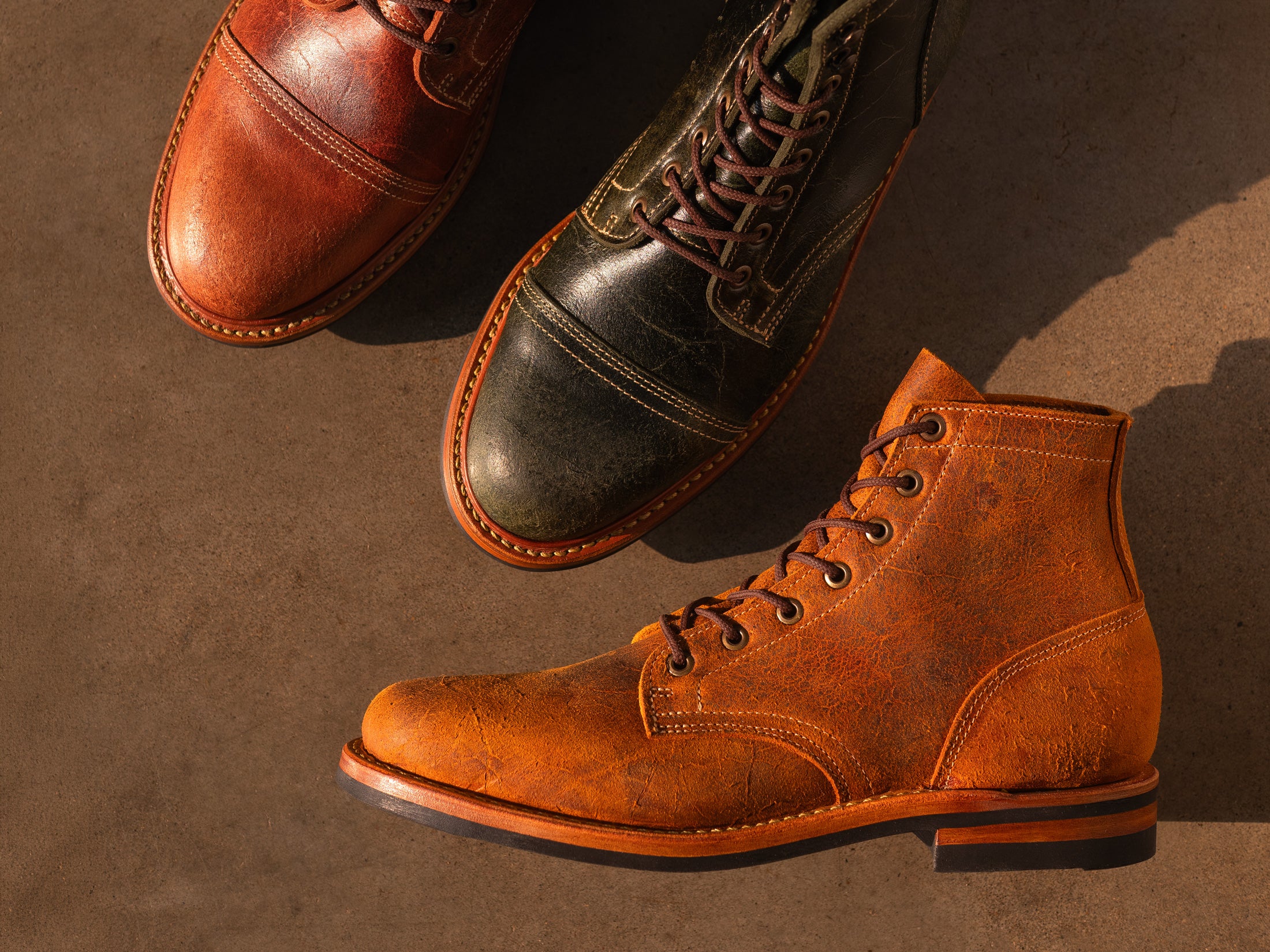 topdown view of textured colored leather boots on smooth concrete floor