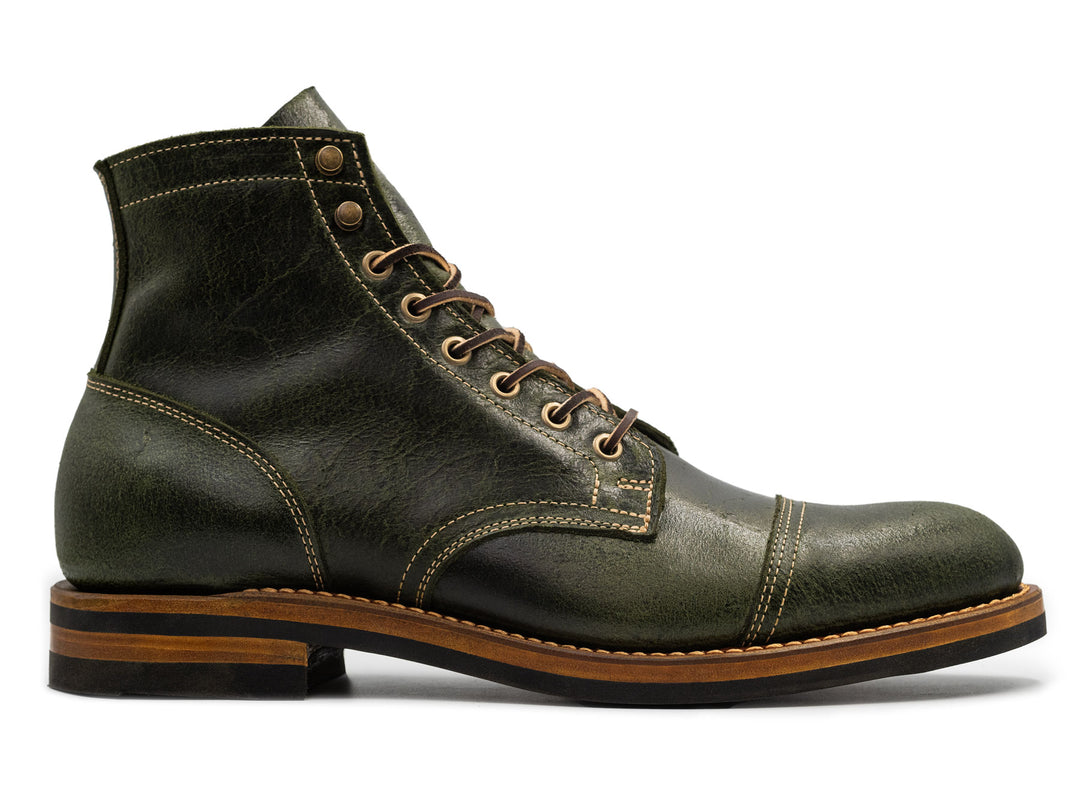 textured green leather boot on white background