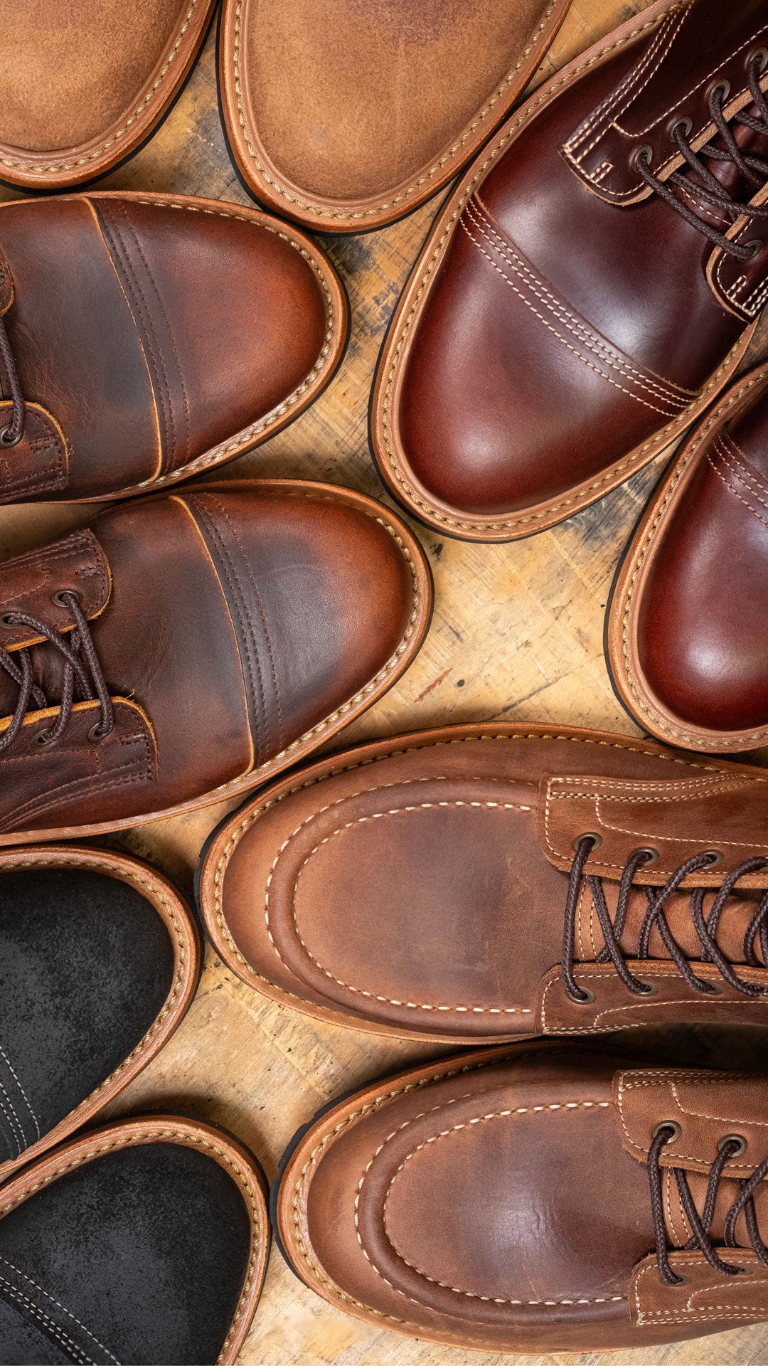 variety of leather boots topdown on wood
