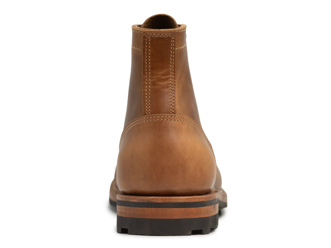 back view of tan caramel leather boot on white background