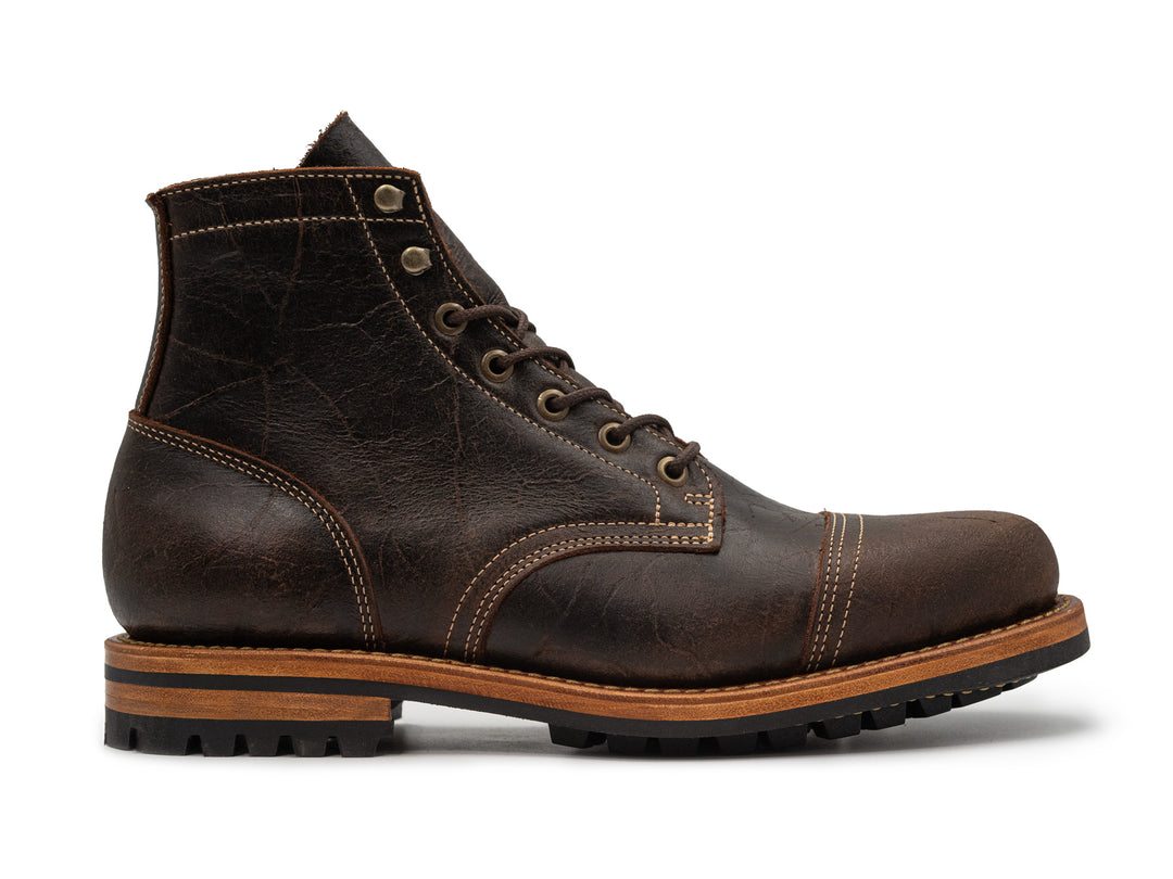 textured brown leather boot on white background