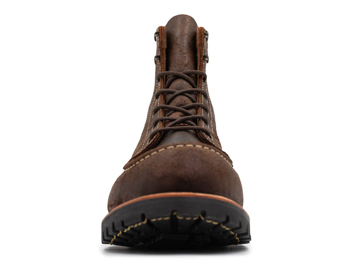 front view of textured brown leather moc toe boots on white background