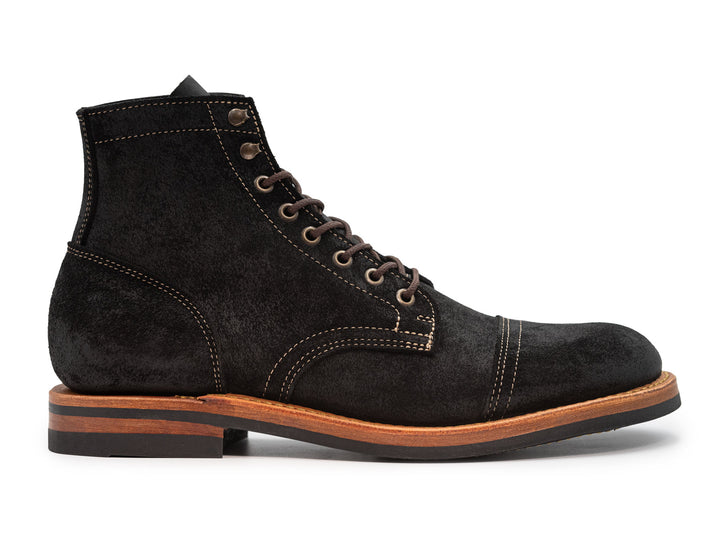 side view of black leather boot on white background
