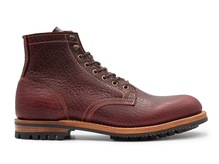 side view of textured burgundy bison leather boot on white background