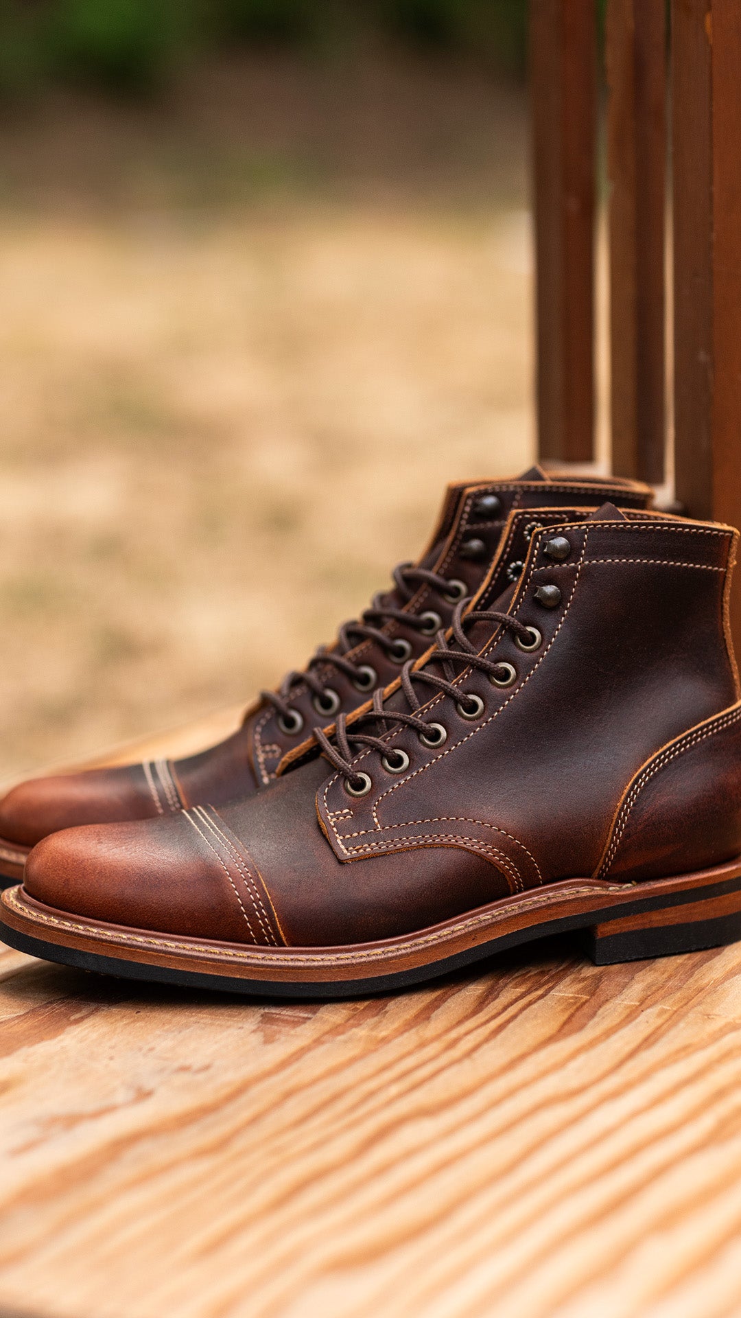 dark leather brown boots on out of focus tan background